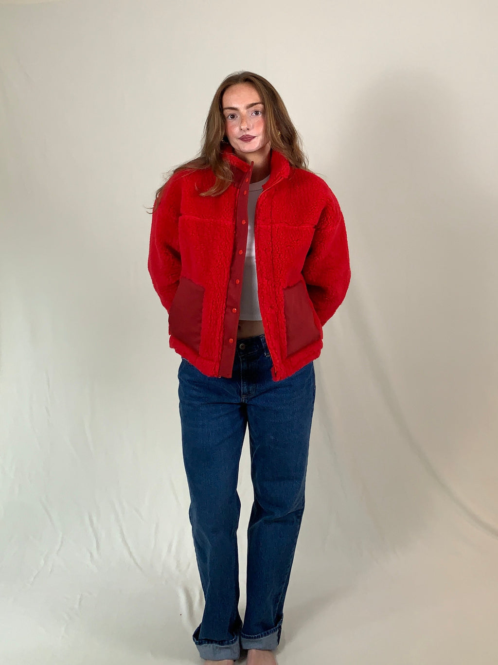 Young woman modeling a red premium sherpa jacket for winter. 