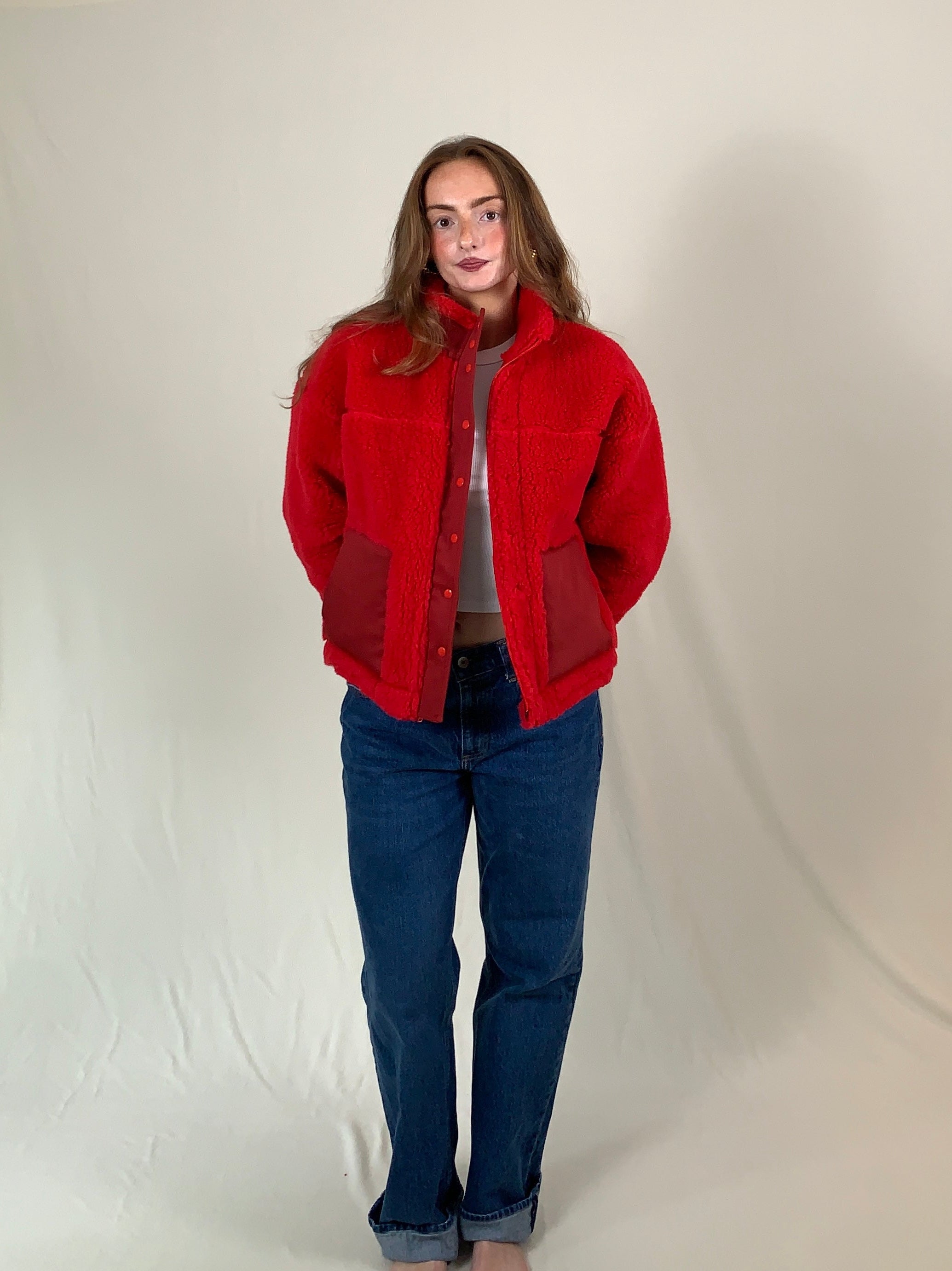 Young woman modeling a red premium sherpa jacket for winter. 